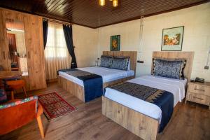 a bedroom with two beds and a table at Levissi boutique hotel in Gaziantep