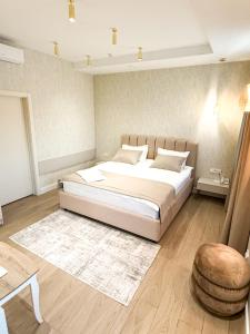 a bedroom with a large bed and a stool at River Stone in Pavlodar +12 photos