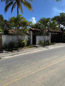 a street with a white fence and palm trees at Suite LUAR in Saquarema