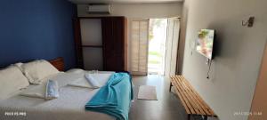 a bedroom with a bed with blue walls and a window at Pousada Casa da Praticagem in Salinópolis