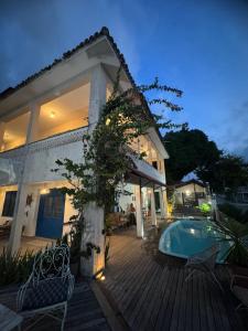 a house with a wooden deck with a swimming pool at Pousada Casa da Praticagem in Salinópolis