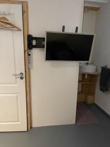 a flat screen tv on a wall next to a door at Mooi Genieten Studio in Middelburg