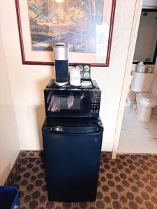 a coffee maker sitting on top of a refrigerator at Travelodge by Wyndham Drumheller AB in Drumheller +101 photos