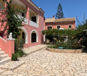 a house with a stone driveway in front of it at Antigoni Apartments in Acharavi