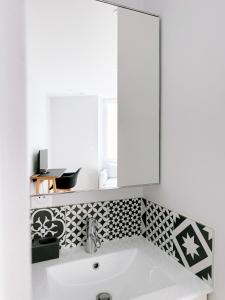 a bathroom with a white sink and a mirror at L'Appart du Faubourg 1 à 8 Personnes in Valence +168 photos