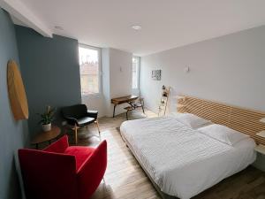a bedroom with a bed and a red chair at L'Appart du Faubourg 1 à 8 Personnes in Valence