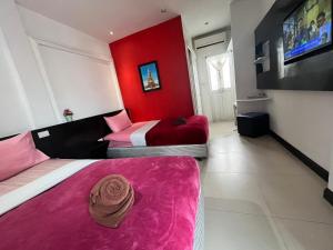 two beds in a room with a red wall at Colorize Boutique Hotel in Lamai