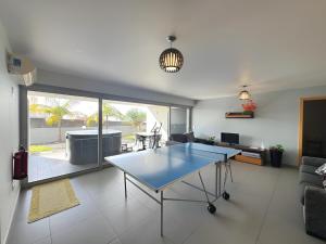 a living room with a ping pong table in it at Blue Villa in Arco da Calheta