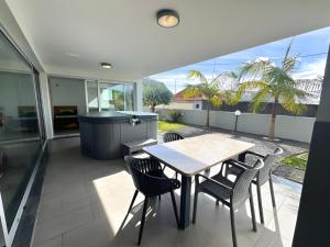 a dining room with a table and chairs on a patio at Blue Villa in Arco da Calheta