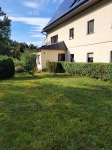 a house with a grass yard next to a building at Ferienwohnung Heider in Dippoldiswalde +3 photos