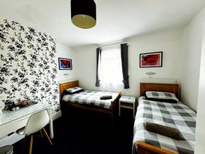 a room with two beds and a sink in it at Aylesford Guesthouse in Kent