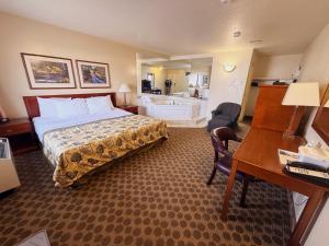 a hotel room with a bed and a desk at Travelodge by Wyndham Drumheller AB in Drumheller