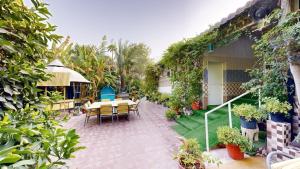 a patio with a table and chairs and plants at Happiness Farm in Hatta