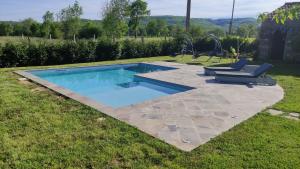 a swimming pool with two lounge chairs in a yard at La Maison d'eglantine in Marnaves