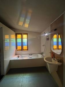 a white bathroom with a tub and a sink at Fort flora in Cochin