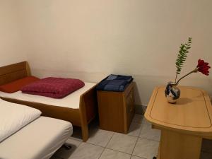 a room with a bed and a table with a flower in a vase at Brakel Monteure Ferienwohnung 1 in Brakel