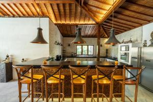 a kitchen with a large center island with chairs around it at 3BDR Villa with Pool Jacuzzi - Canggu in Dalung