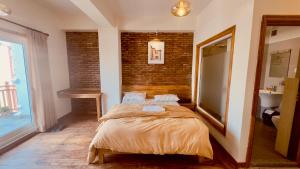 a bedroom with a bed and a brick wall at Circle of Life in Baudhatinchule