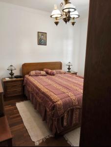a bedroom with a bed with a red bedspread at Aurélio & Zezinha House in Penamacor