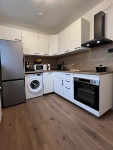 a kitchen with white cabinets and a washer and dryer at Friendly Space Apartment in Graz