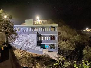 a large white building at night with lights at Djabraba's space in Garça