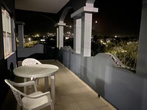 a table and chairs on a balcony at night at Djabraba's space in Garça