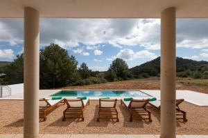 a patio with chairs and a swimming pool at Villa Es Redo-Spacious & Relax in Sant Josep de sa Talaia