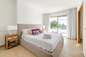 a bedroom with a large bed and a large window at Villa Es Redo-Spacious & Relax in Sant Josep de sa Talaia