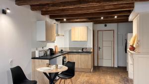 a kitchen with a table and chairs in a room at Le Chêne Doré in Bellac