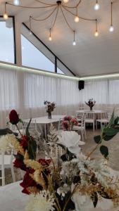 a banquet hall with tables and chairs with flowers at La Căsuțe Luxury in Piatra Neamţ