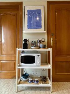a microwave on a shelf next to a door at Habitación Atalaya in Olivella