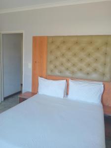 a bedroom with a large white bed with a large headboard at Star Legend lodge in Parow
