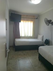 a small room with two beds and a window at Star Legend lodge in Parow