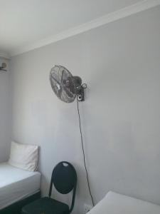 a room with a bed and a fan and a chair at Star Legend lodge in Parow