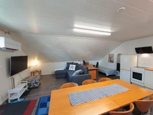 a living room with a dining table and a kitchen at Penthouse with a balcony in Hyvinkää