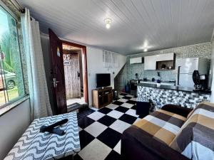 a living room with a couch and a kitchen at Casa de praia em Itacuruçá in Mangaratiba