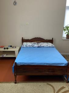 a bed in a room with a blue blanket on it at Holiday home in Qusar