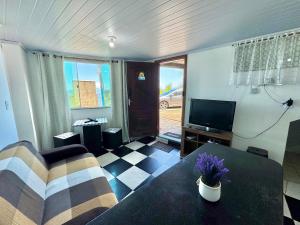 a living room with a couch and a table and a tv at Casa de praia em Itacuruçá in Mangaratiba