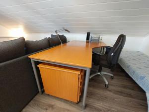 an office with a desk and a couch and a desk and chair at Penthouse with a balcony in Hyvinkää