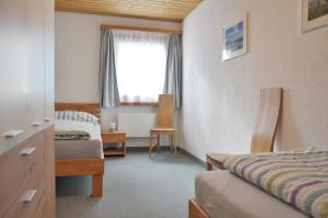 a hotel room with a bed and a window at Chasa Arlu in Samnaun +5 photos