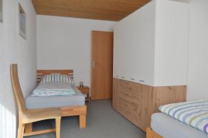 a small bedroom with a bed and a dresser at Chasa Arlu in Samnaun