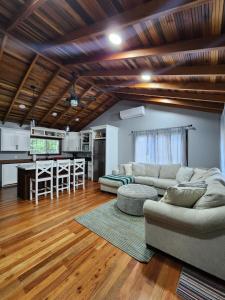 a living room with two couches and a kitchen at Cozy Yellow Cottage in Spanish Lookout
