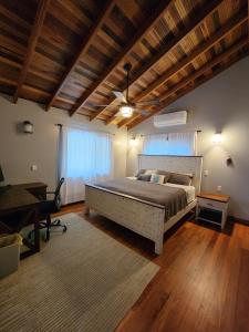 a bedroom with a large bed and a desk at Cozy Yellow Cottage in Spanish Lookout