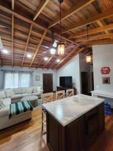 a kitchen and living room with a large island in a room at Cozy Yellow Cottage in Spanish Lookout