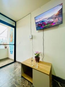 a living room with a tv on the wall at Dulce & Guanábana suite House in Canoa