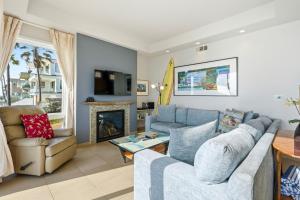 a living room with a couch and a fireplace at Oceanfront 3BR Condo, Balcony, Fire Pit, Shared Beach, Sleeps 6 in Oceanside