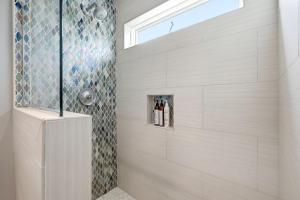a shower in a bathroom with a window at Oceanfront 3BR Condo, Balcony, Fire Pit, Shared Beach, Sleeps 6 in Oceanside +33 photos