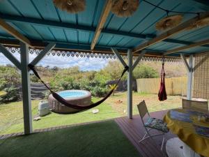 a patio with a hammock and a pool at Kaz a Ma-Lu in Le Marin