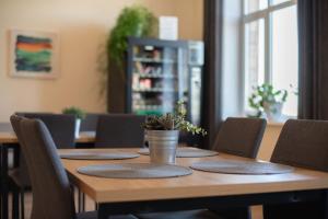 a wooden table with chairs and a potted plant on it at Stoties Hostelis in Vilnius