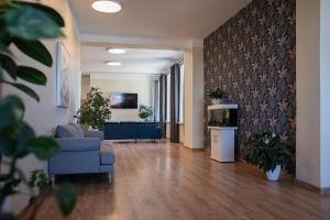 a lobby with a blue chair and a couch at Stoties Hostelis in Vilnius